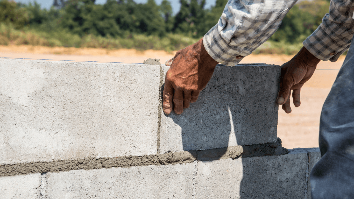 “Worker placing concrete blocks by hand to build a sturdy wall during concrete services in Pine Hills, FL”