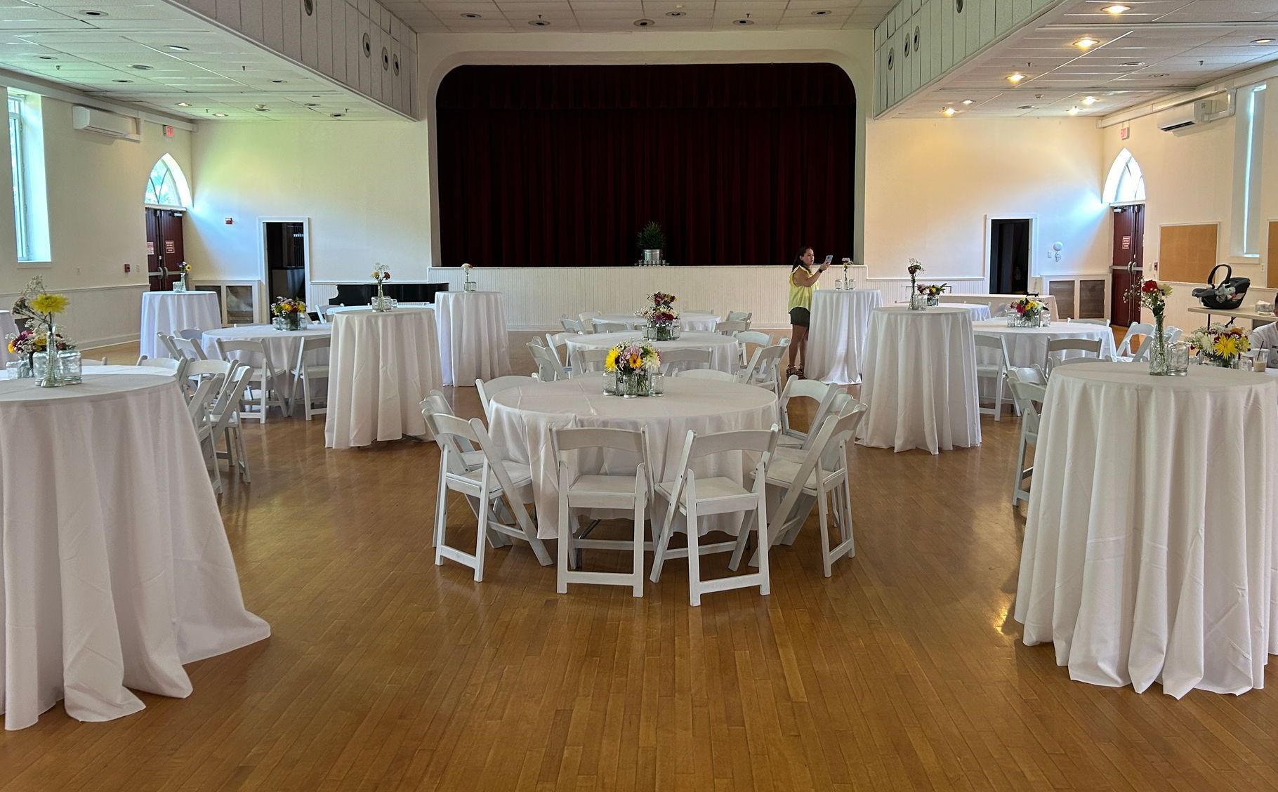 A large room with tables and chairs set up for a party.