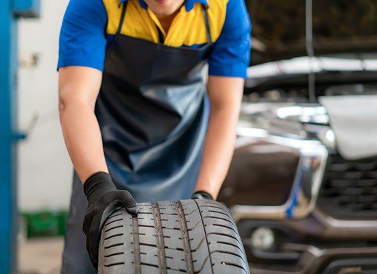 Man At Work Holding Tire — Peekskill, NY — American Cycle & Tire Man At Work Holding Tire — Peekskill, NY — American Cycle & Tire