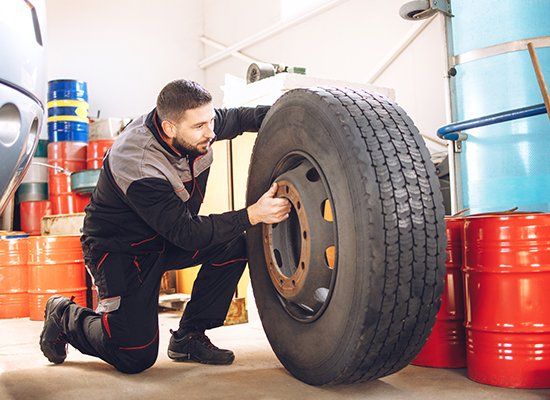 Worker Holding Tire — Peekskill, NY — American Cycle & Tire Worker Holding Tire — Peekskill, NY — American Cycle & Tire