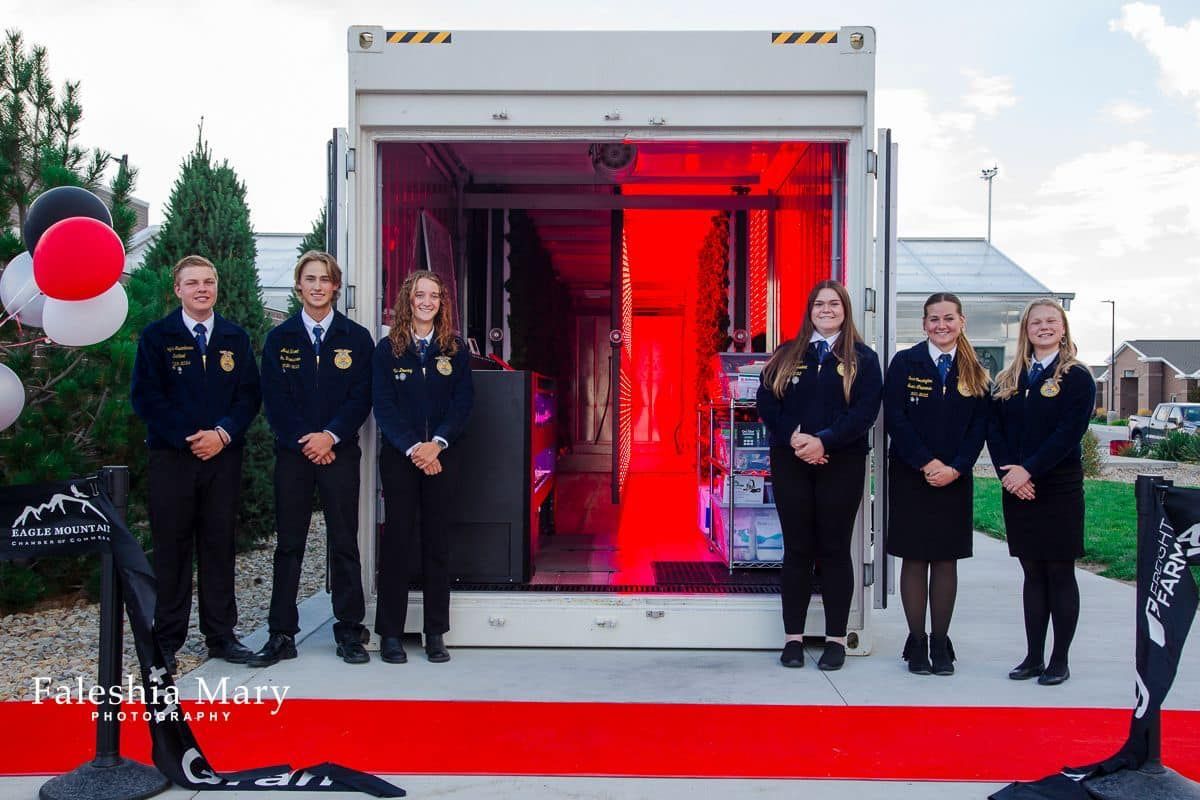 A group of people standing in front of a truck with a red light coming out of it.