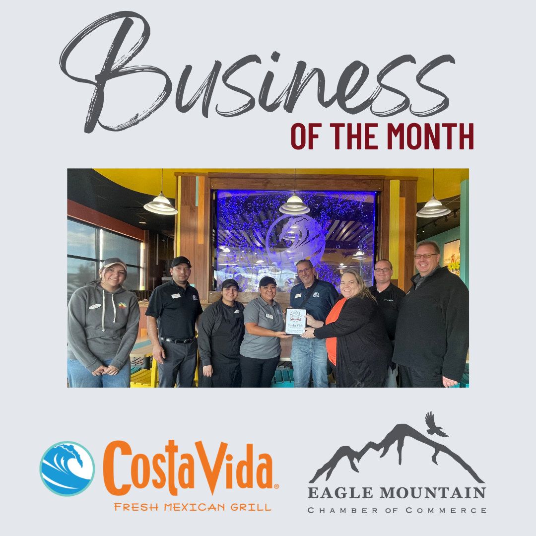 A group of people standing in front of a sign that says business of the month