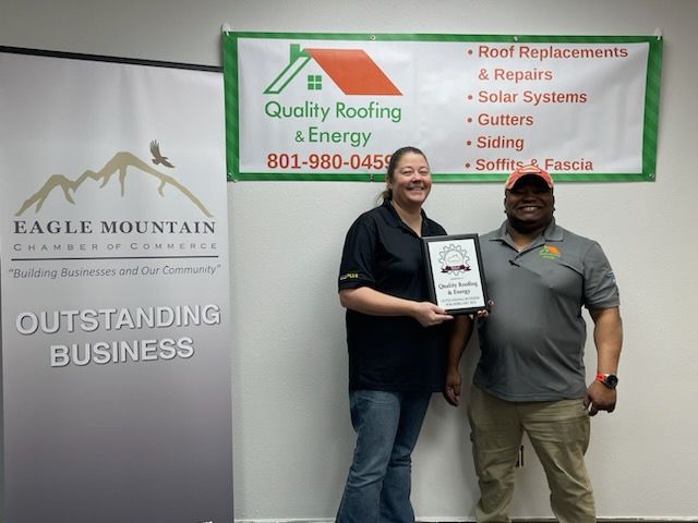 A man and a woman standing in front of an eagle mountain sign