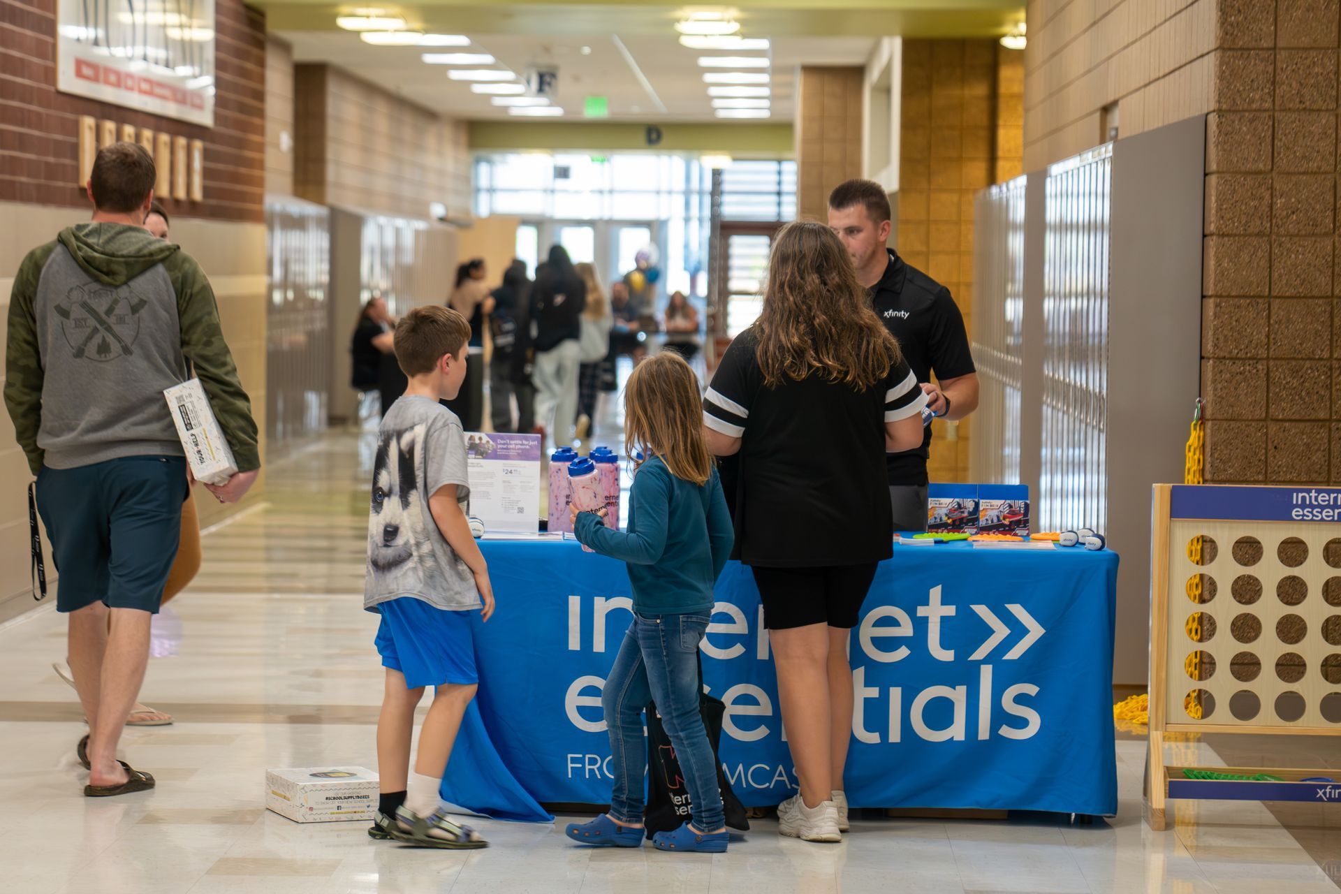A group of people are standing around a table in a hallway.
