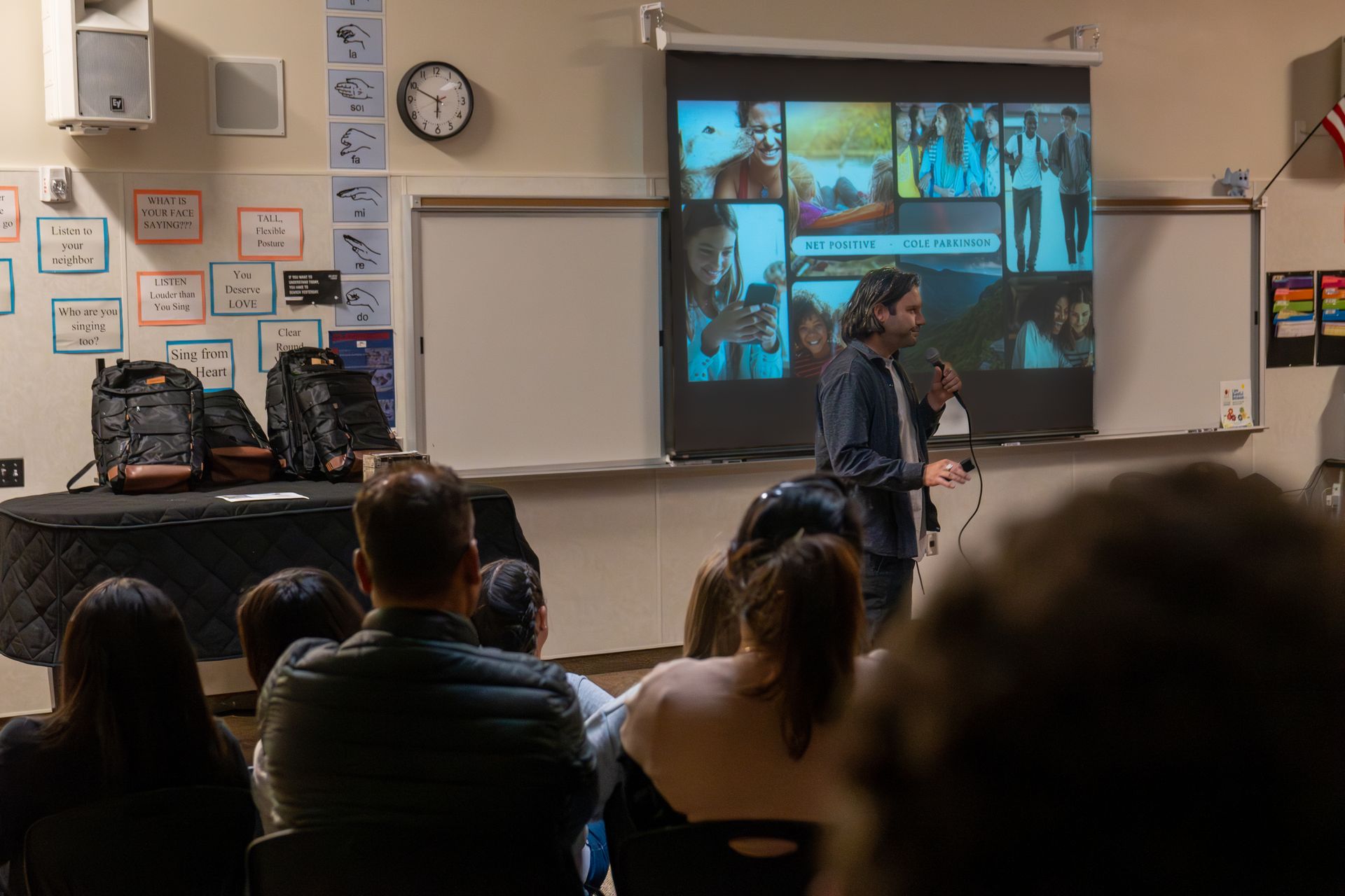 A man is giving a presentation to a group of people in a classroom.