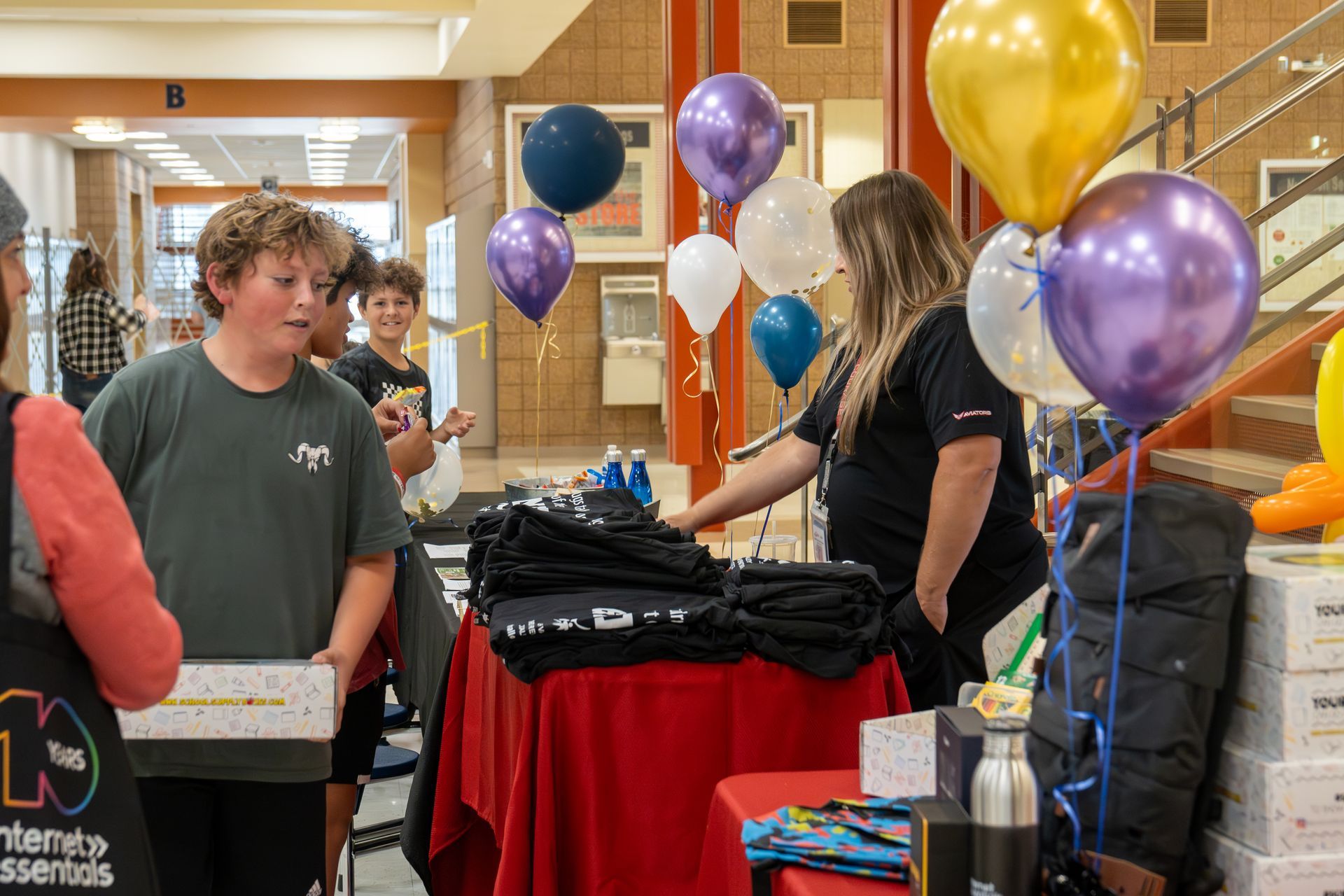 A group of people are standing around a table with balloons.