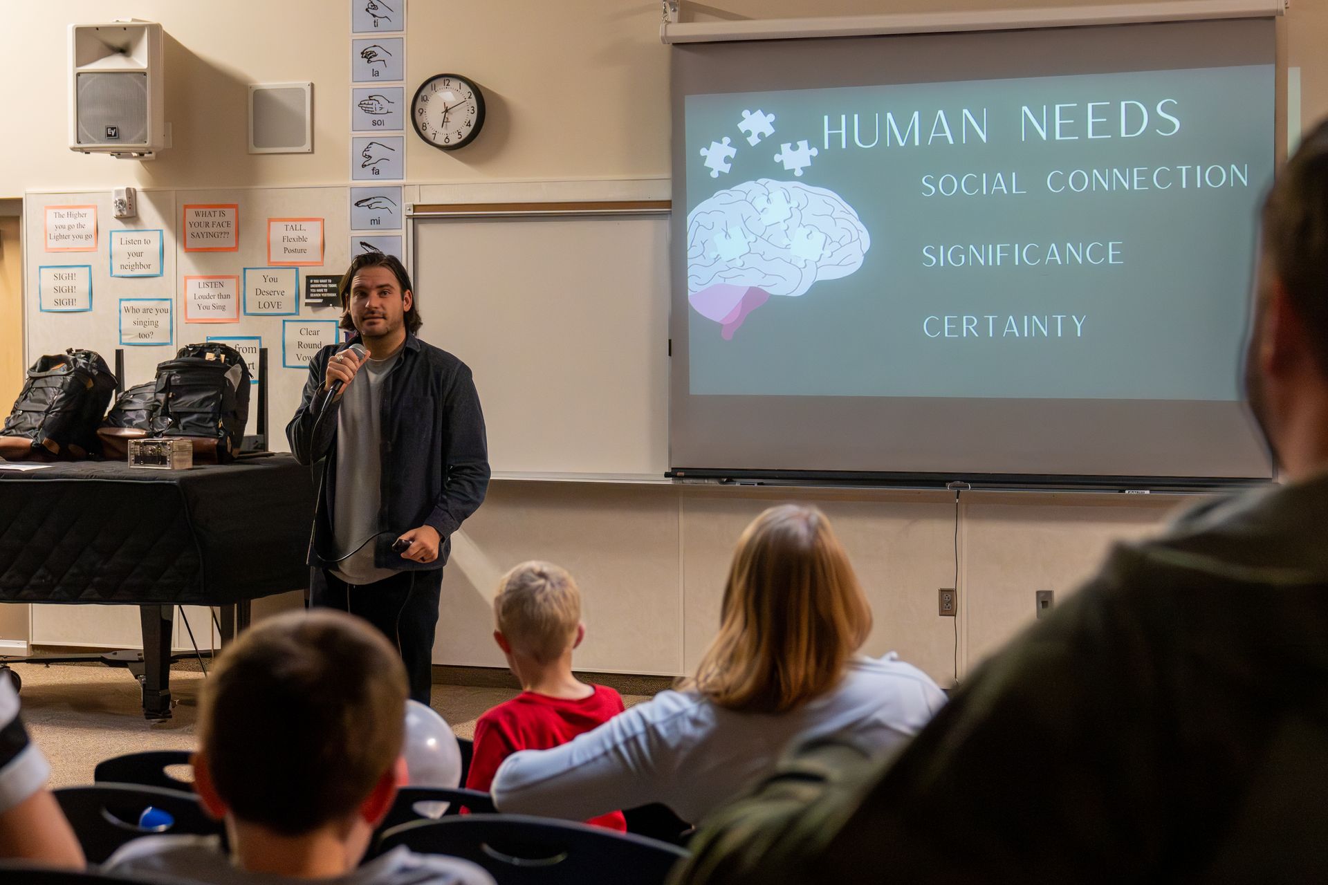 A man is giving a presentation to a group of people in a classroom.