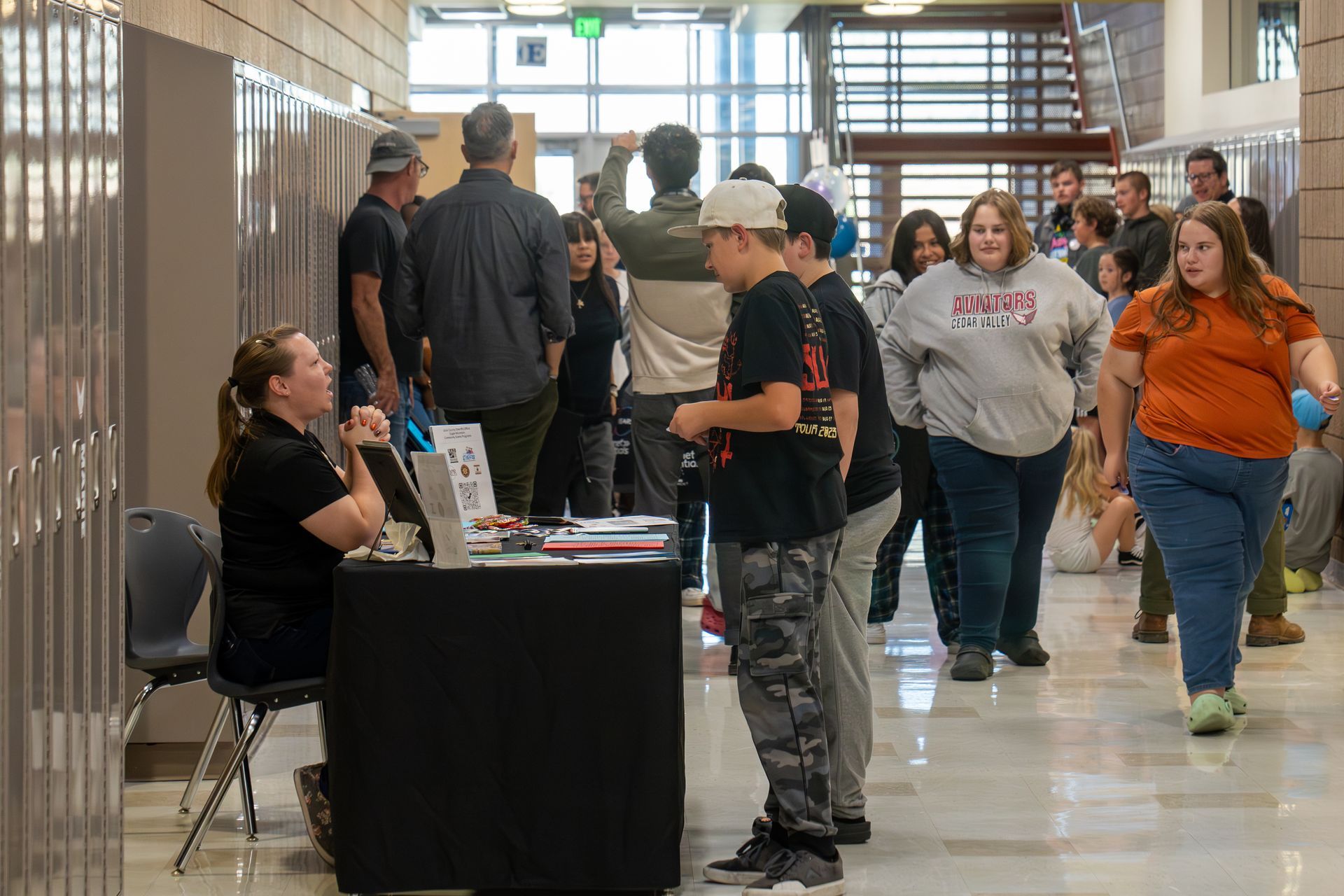A group of people are standing around a table in a hallway.