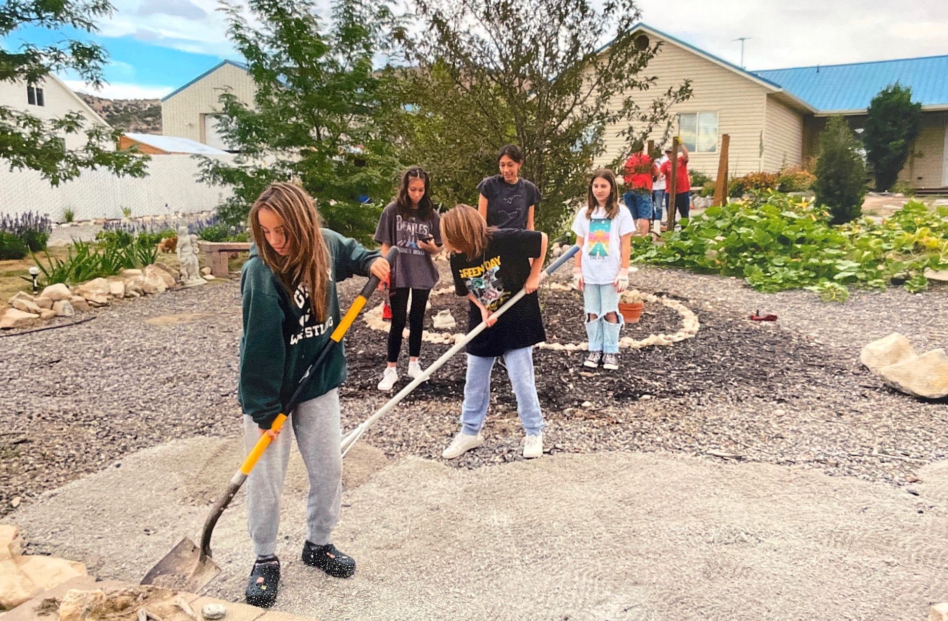 A group of young people are working in a garden.