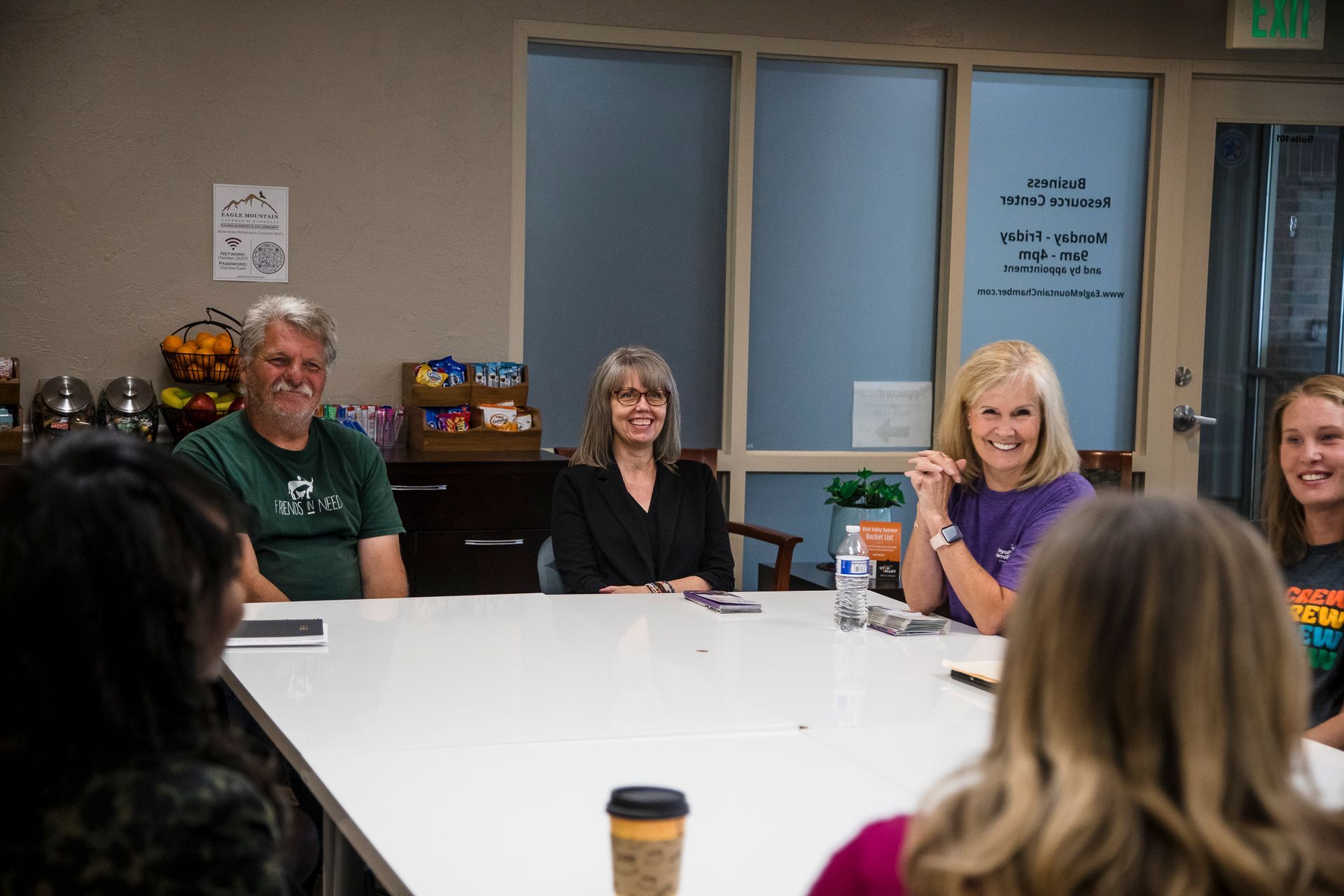 A group of people are sitting around a table in a room.