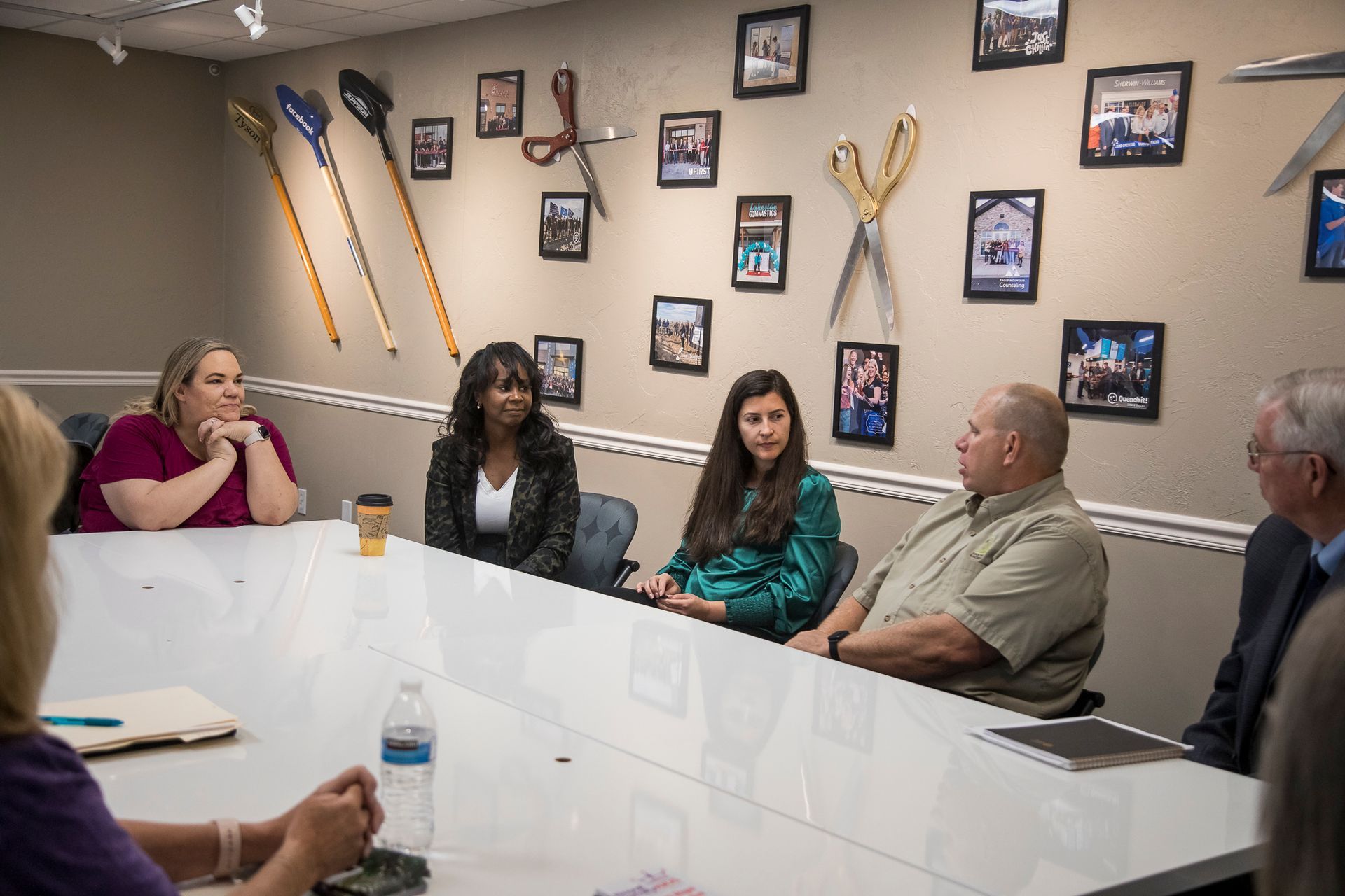 A group of people are sitting around a table in a conference room.