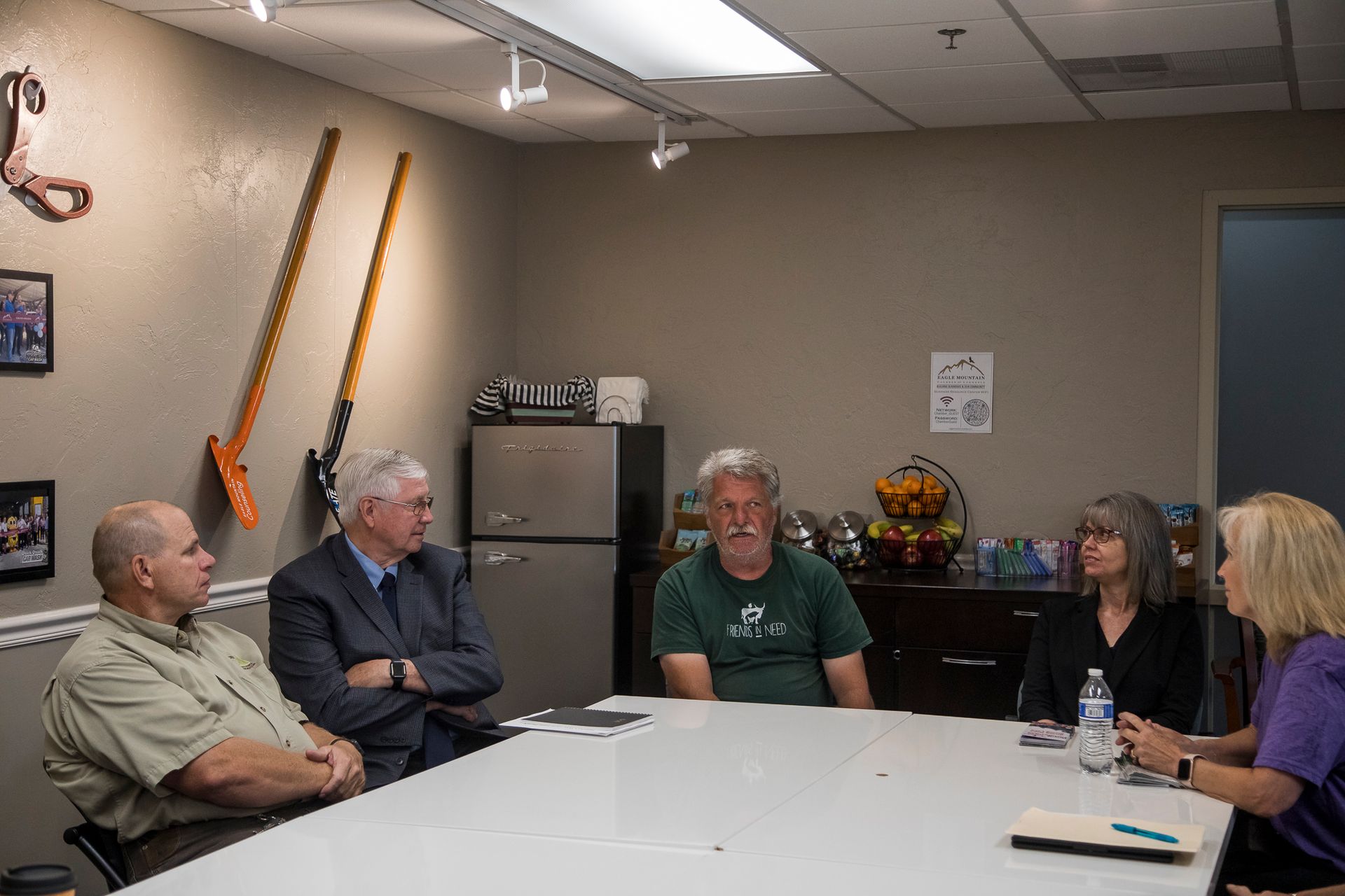 A group of people are sitting around a table in a room.