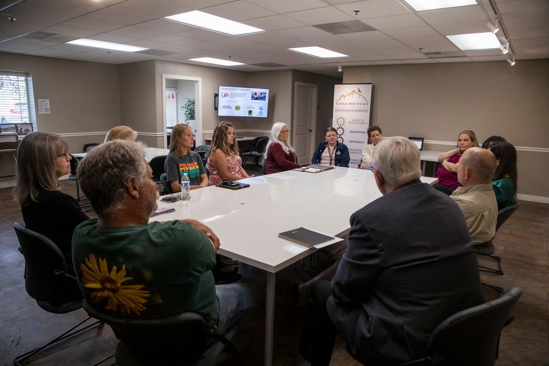 A group of people are sitting around a table in a conference room.
