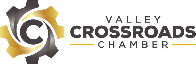 A logo for the valley crossroads chamber with a gear in the middle.