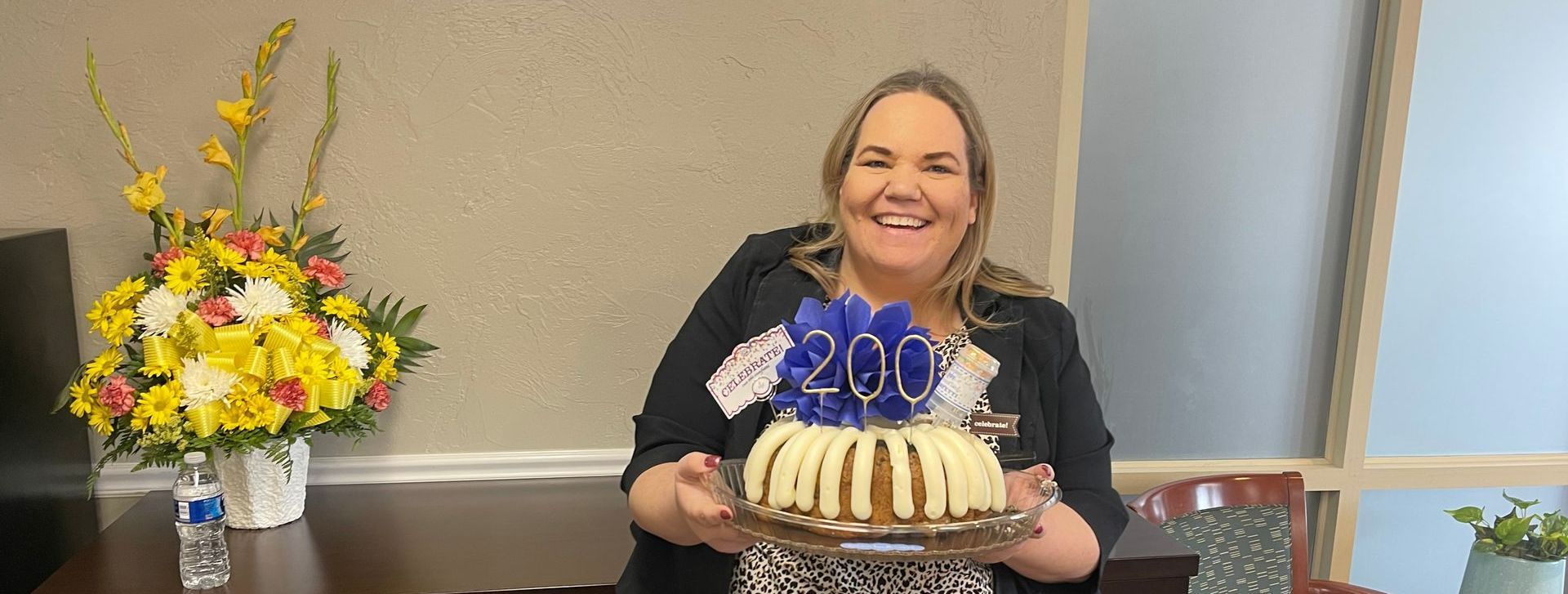 A woman is holding a cake with candles on it.