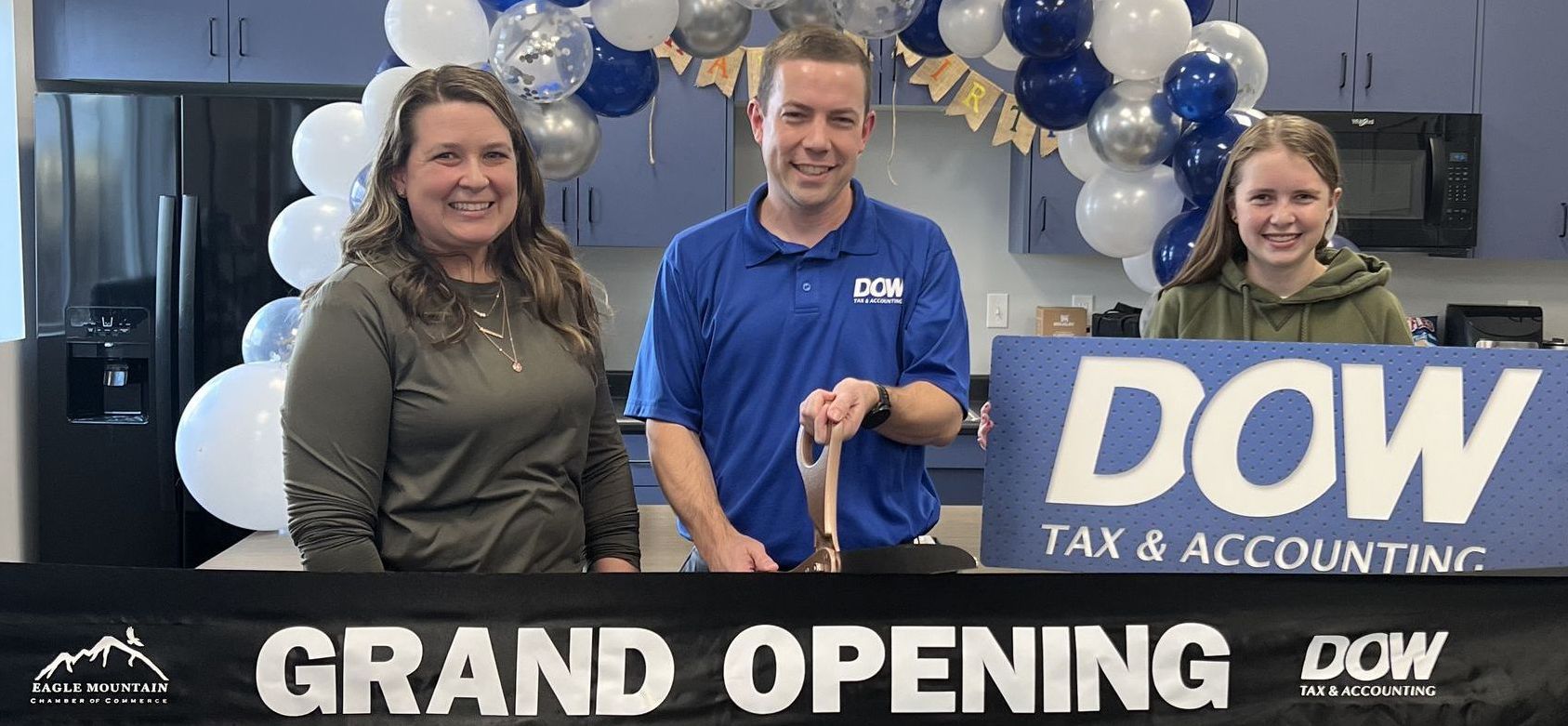 A group of people are standing in front of a sign that says `` grand opening ''.