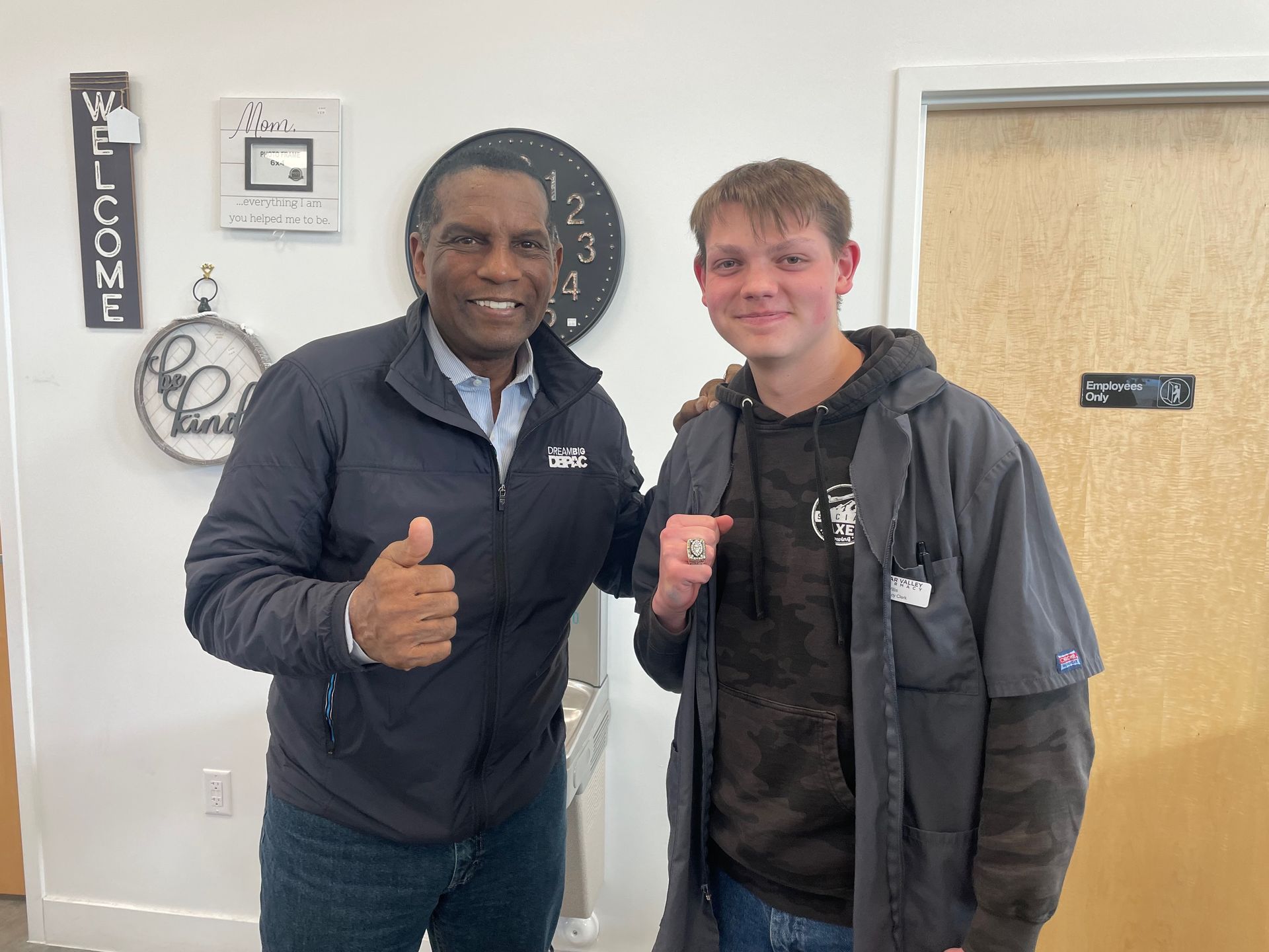 A man and a boy are posing for a picture and the man is giving the boy a thumbs up.