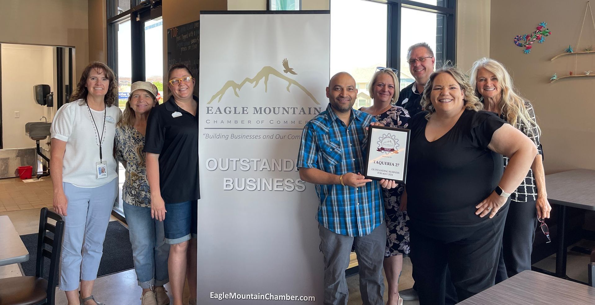 A group of people are posing for a picture in front of a sign that says quiet and business.