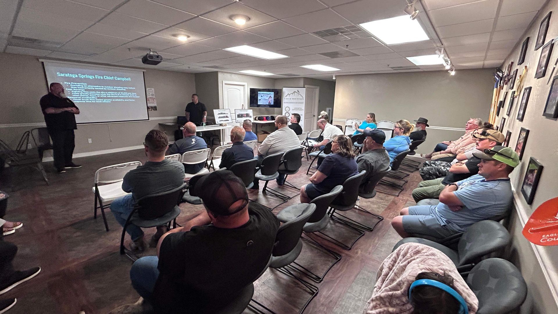 A group of people are sitting in a room watching a presentation.