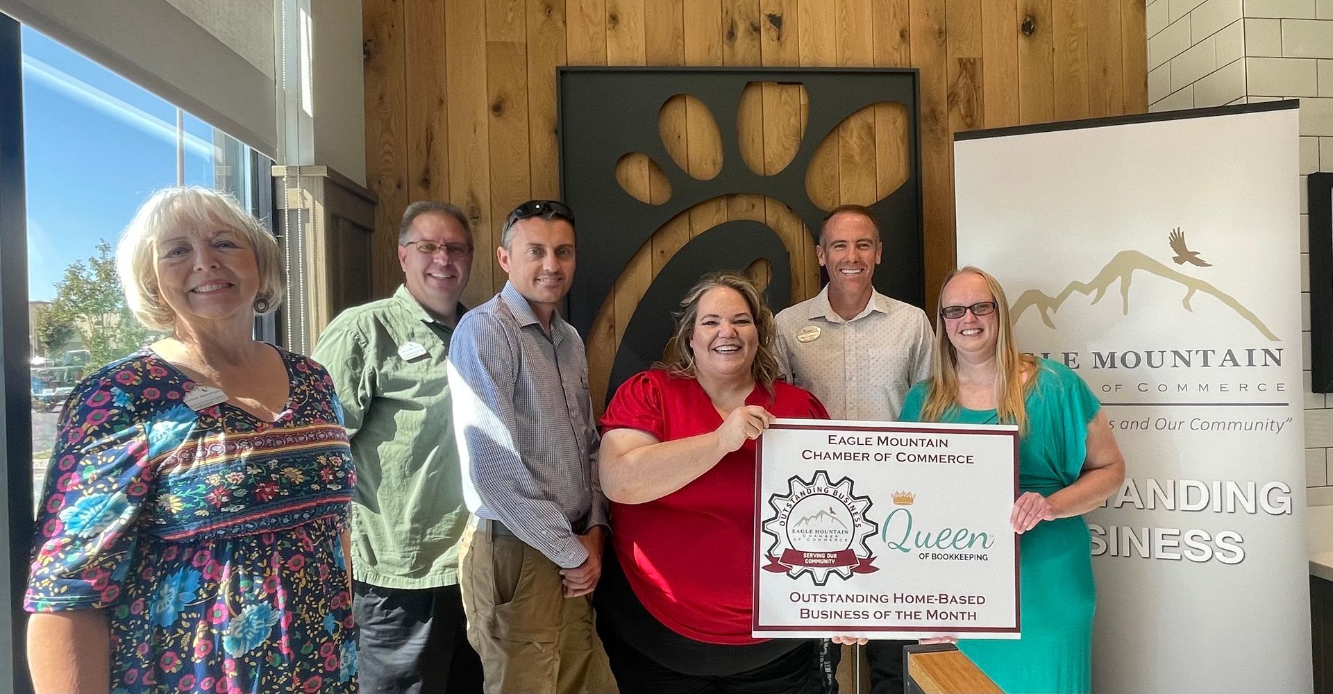 A group of people standing next to each other holding a check.