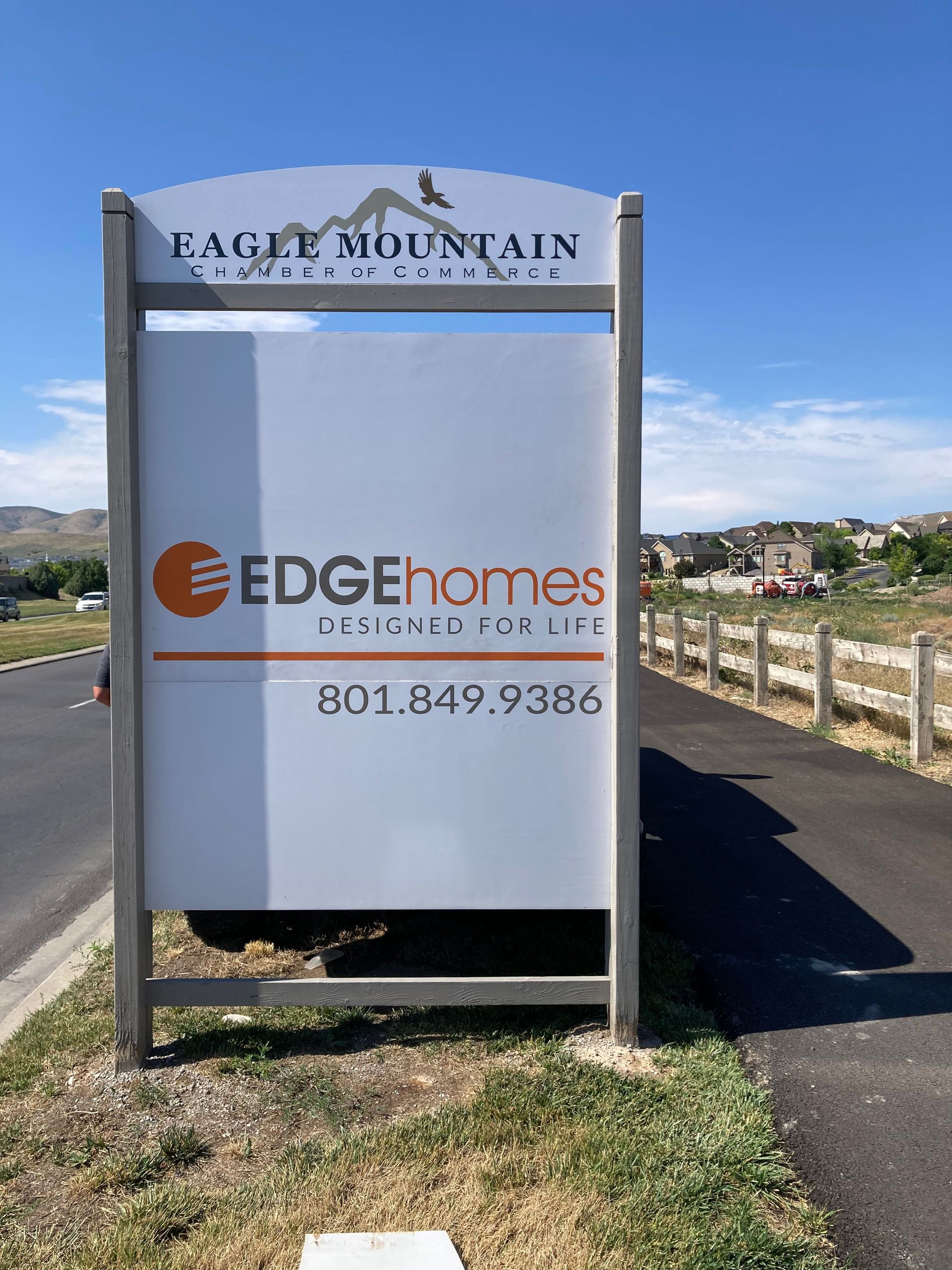 A sign for edgehomes is sitting on the side of the road.