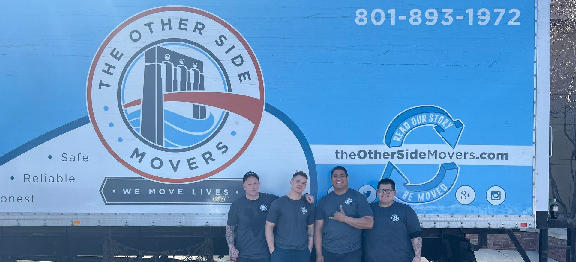 A group of men are standing in front of a moving truck.