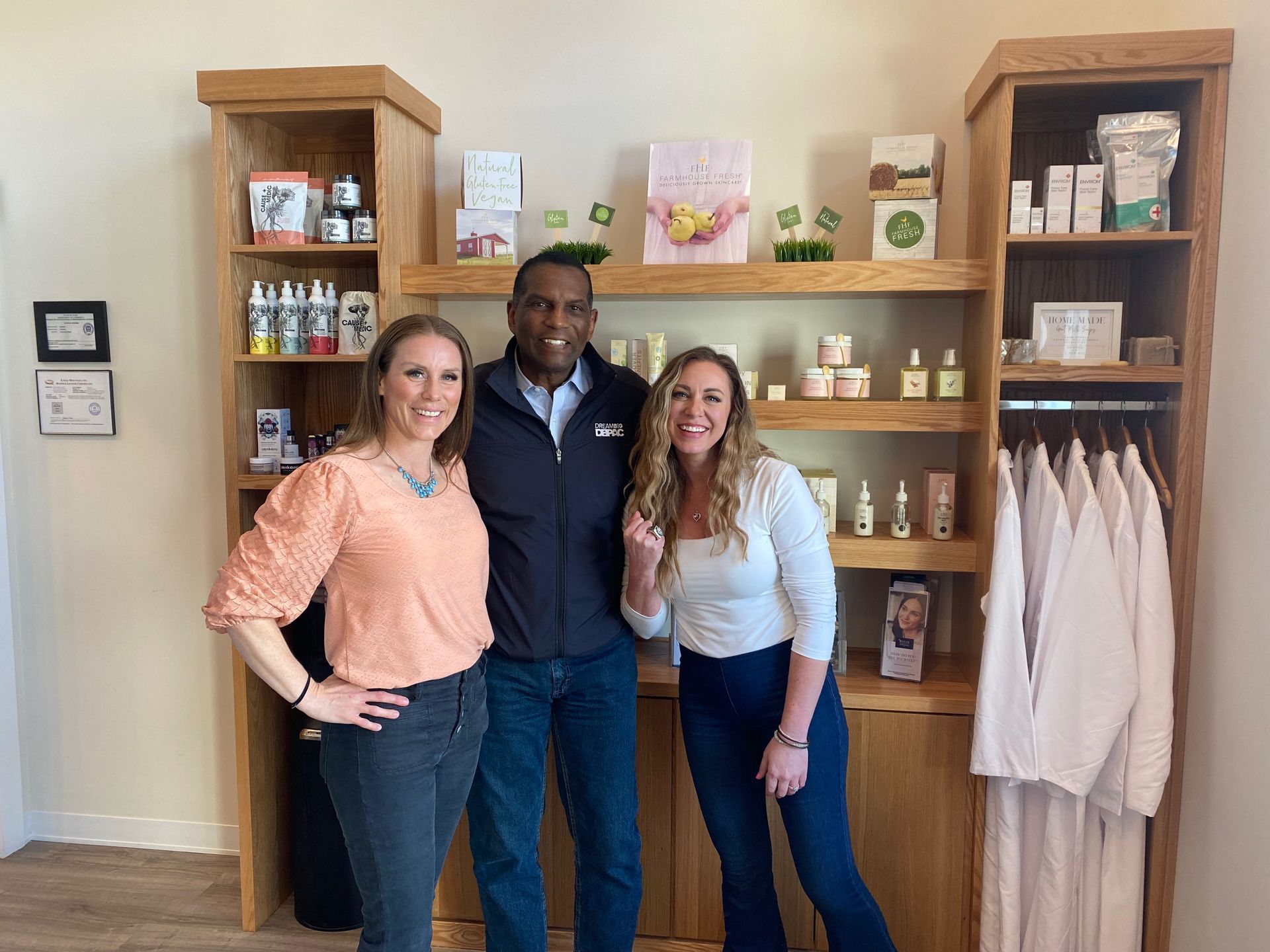 A man and two women are posing for a picture in a store.