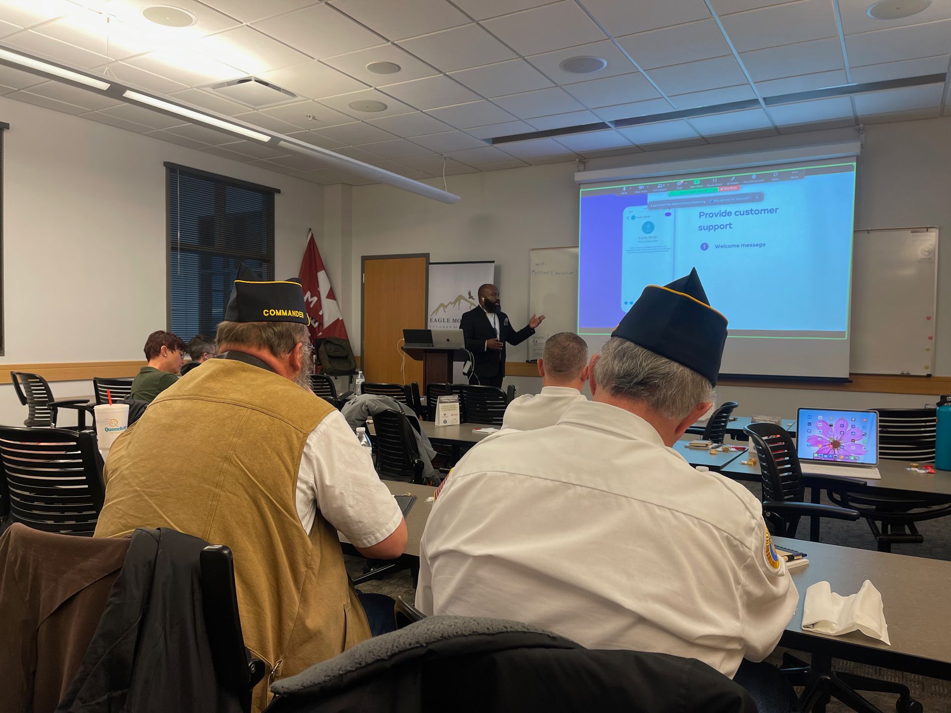 A man is giving a presentation to a group of people in a classroom.