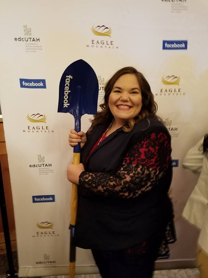 A woman is holding a shovel that says facebook on it