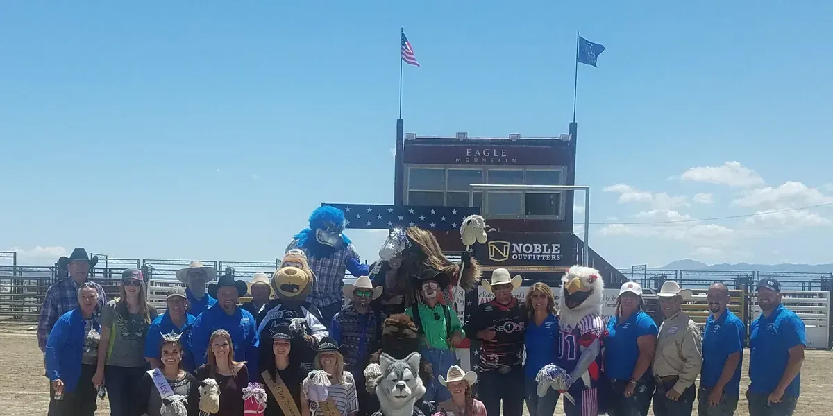 A group of people are posing for a picture in front of a truck.