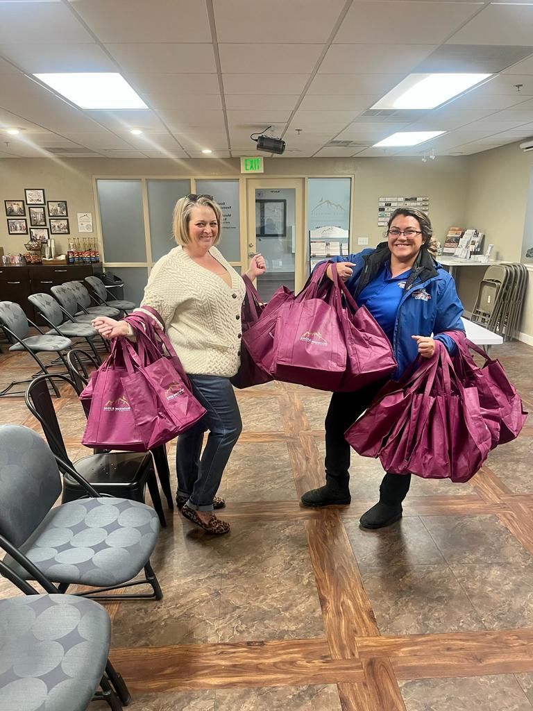 Two women are holding purple bags in a waiting room.