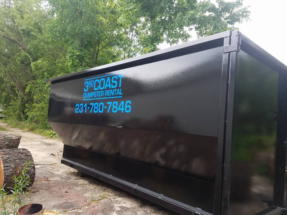 Black dumpster with teal text reading 