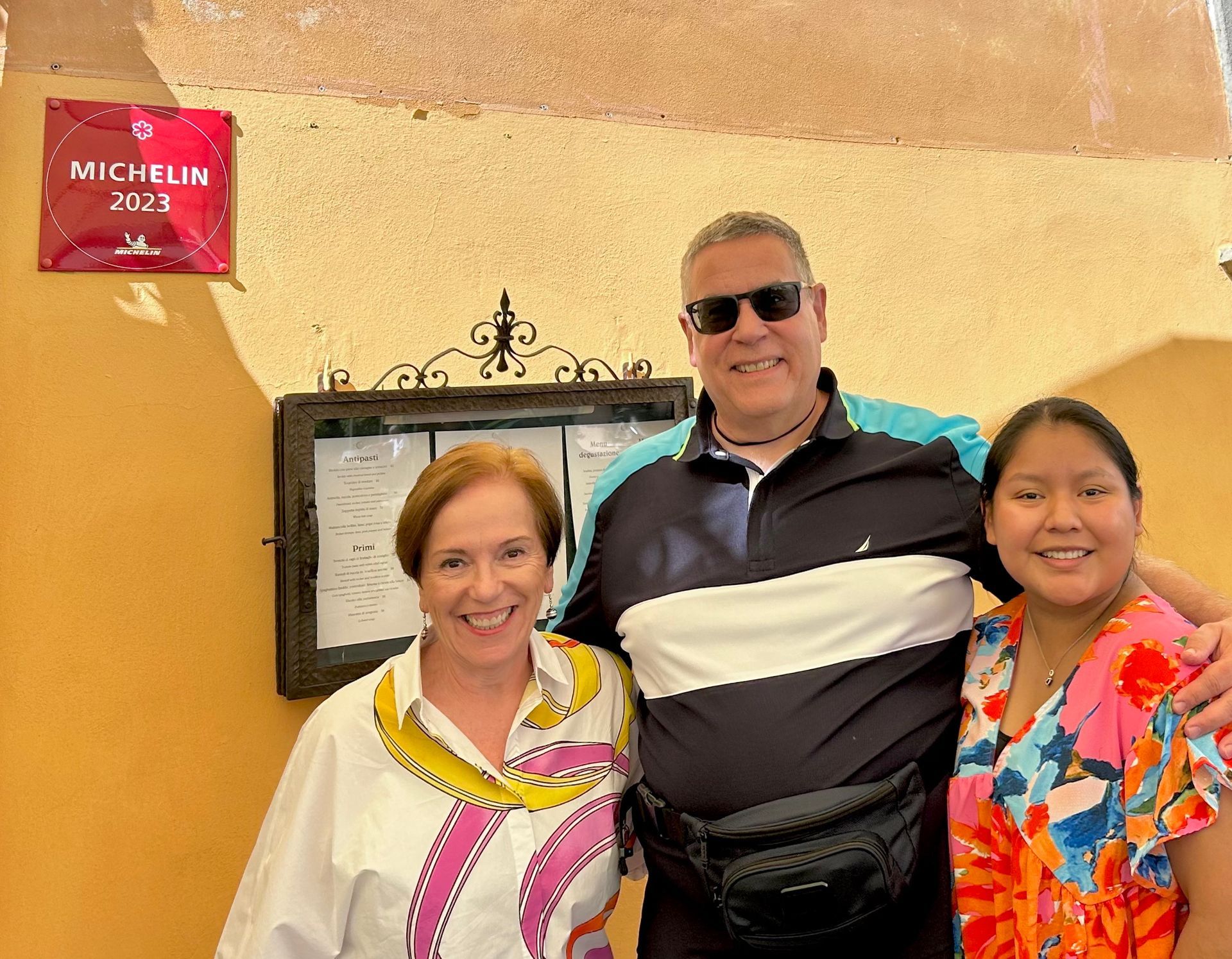 A man and two women pose for a picture in front of a michelin sign