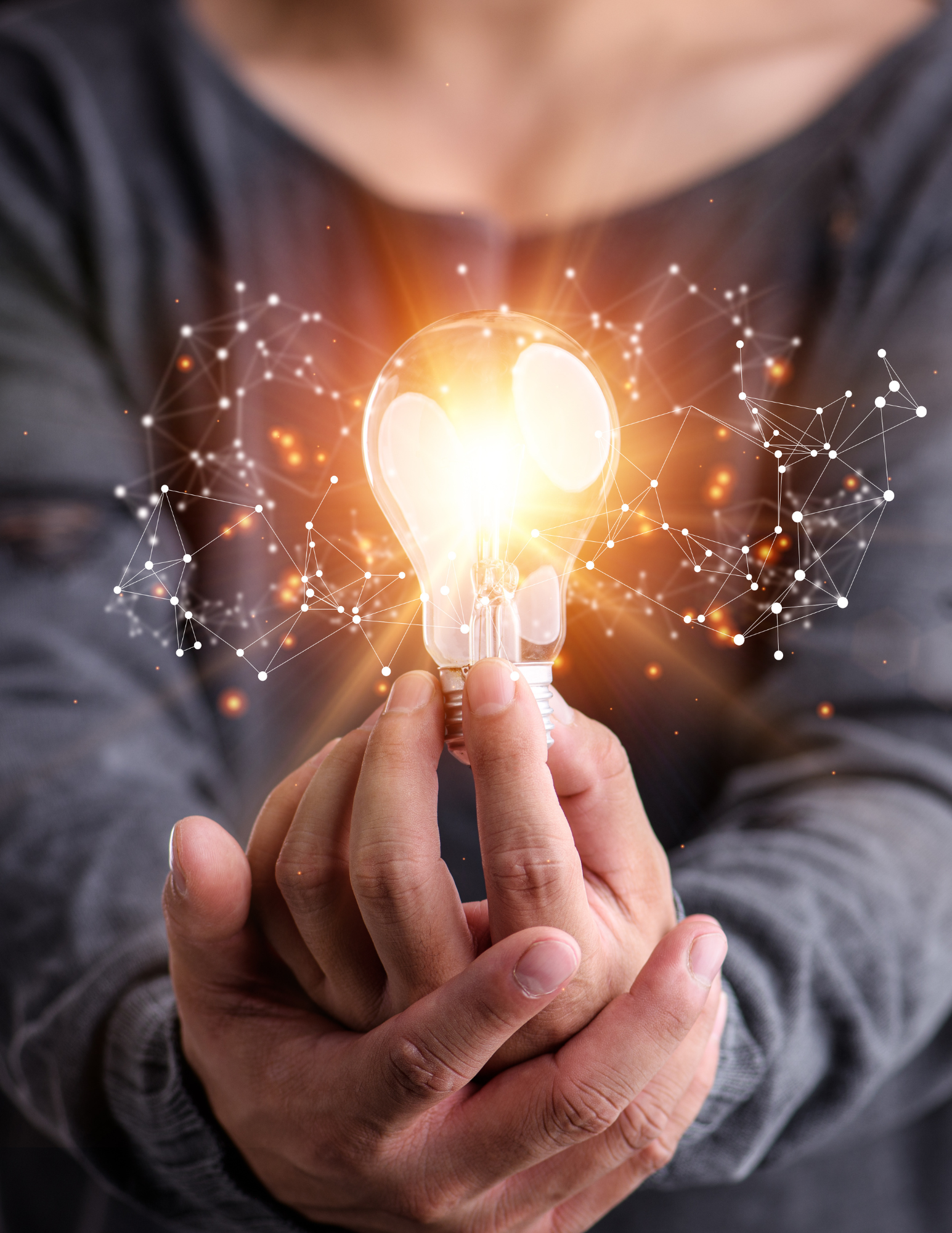 A person is holding a light bulb in their hands