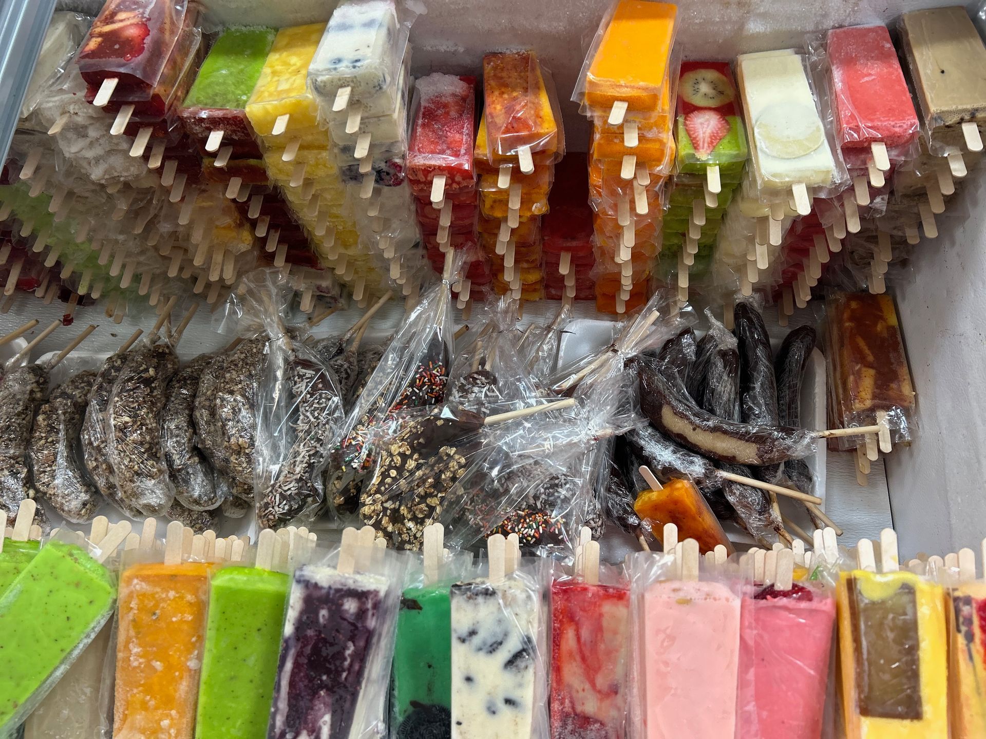 A display case filled with lots of different flavored popsicles.