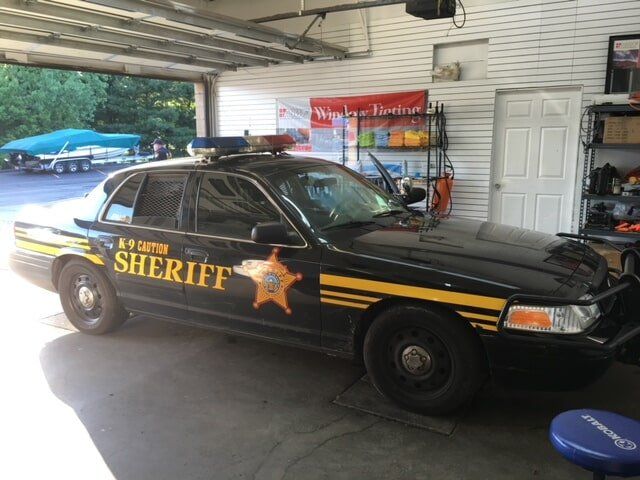 A sheriff 's car is parked in a garage