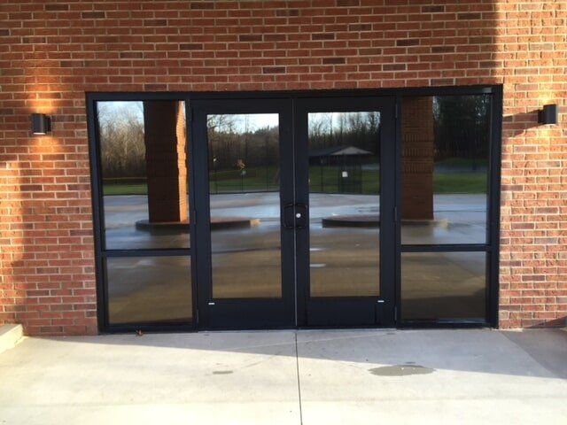 A brick building with a black glass door