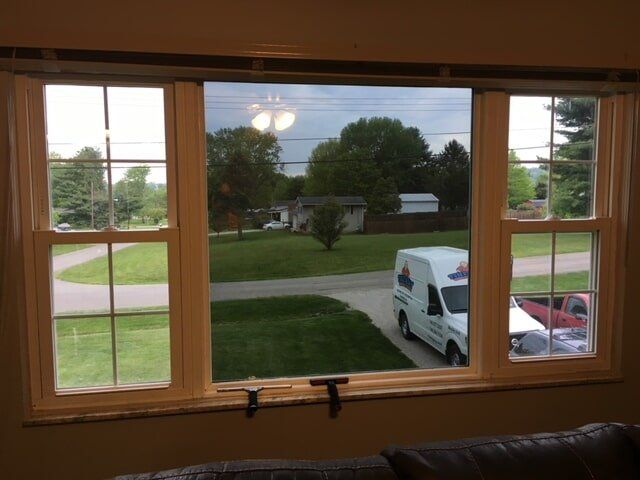 A white van is parked in front of a window in a living room
