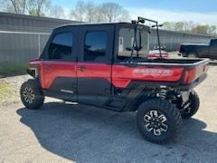 A red and black utility vehicle is parked in a parking lot.