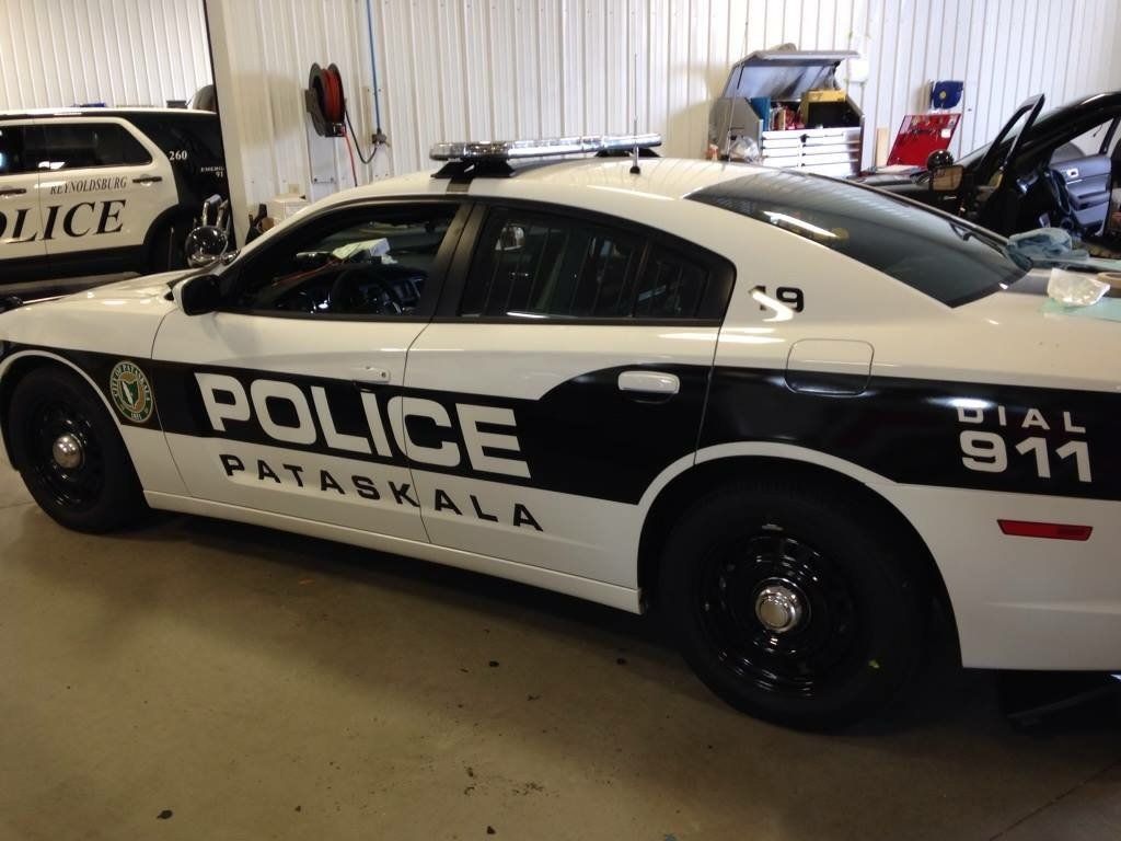 A black and white police car is parked in a garage