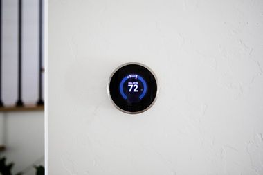 Smart thermostat displaying 72°F on a white wall