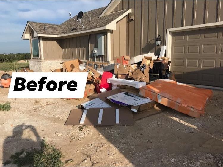 A pile of cardboard boxes is in front of a house.