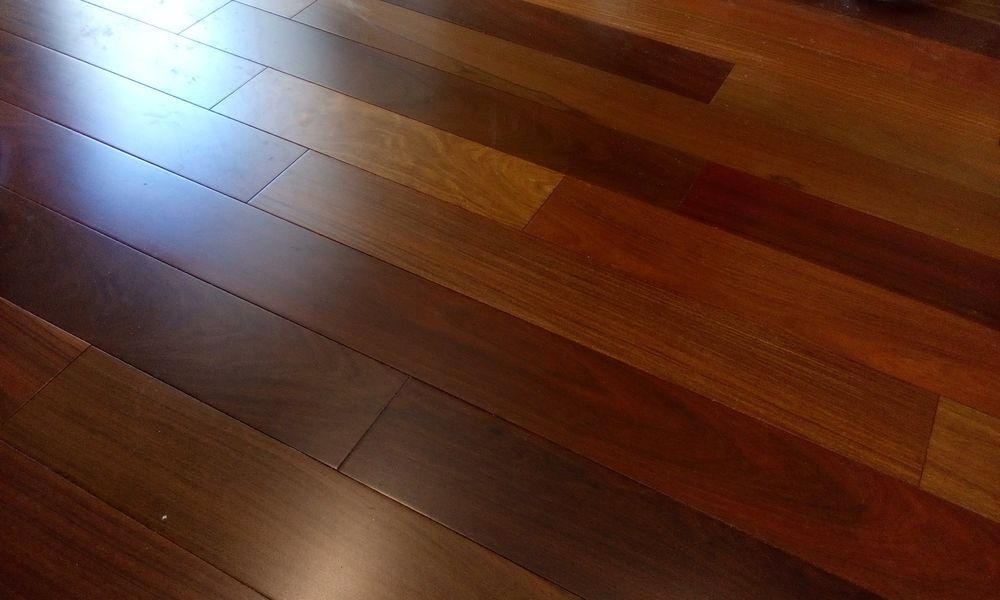 Hardwood floor with alternating dark and light brown planks, angled view.