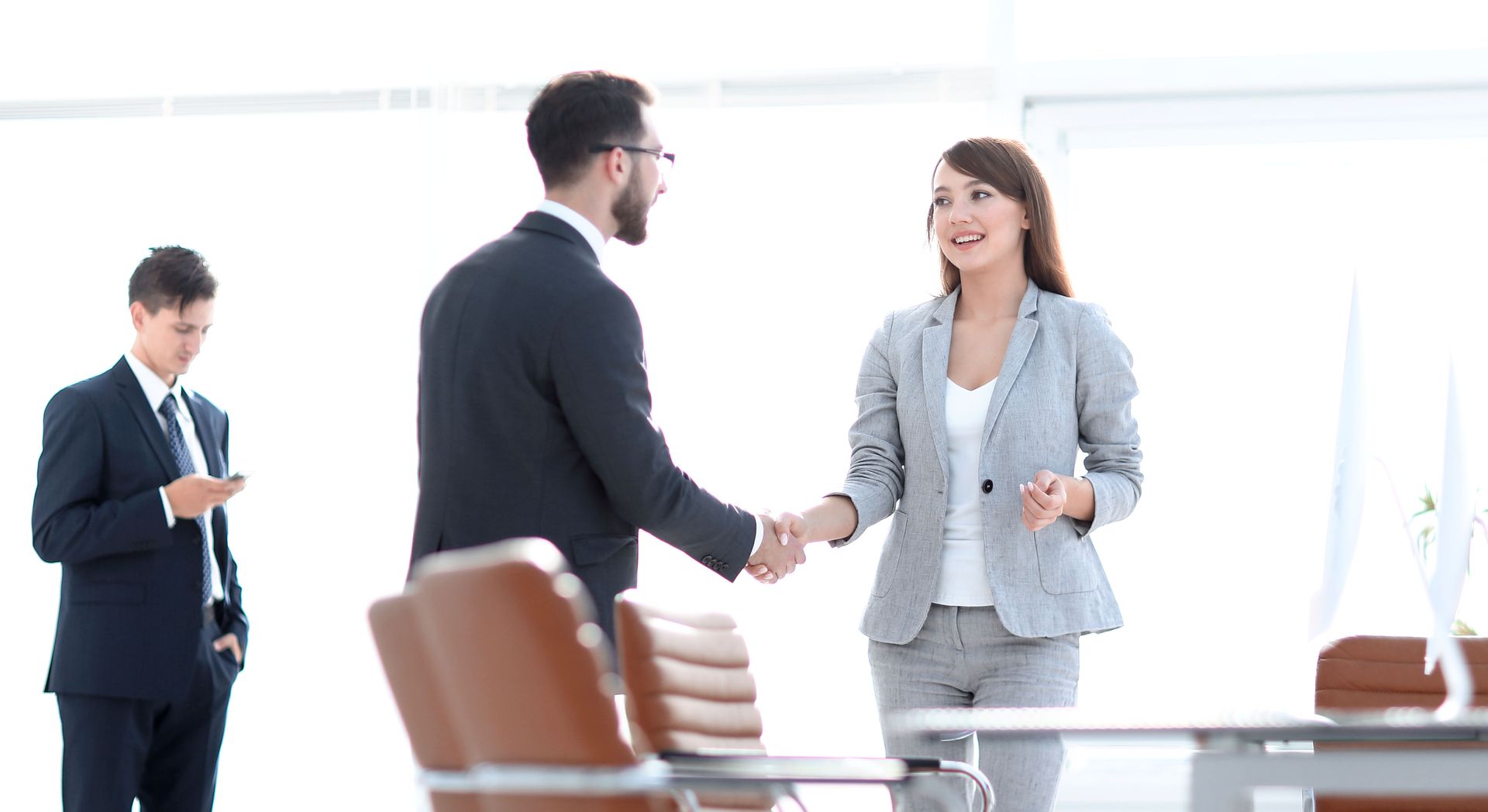 man and woman shaking hands A man and a woman are shaking hands in an office.