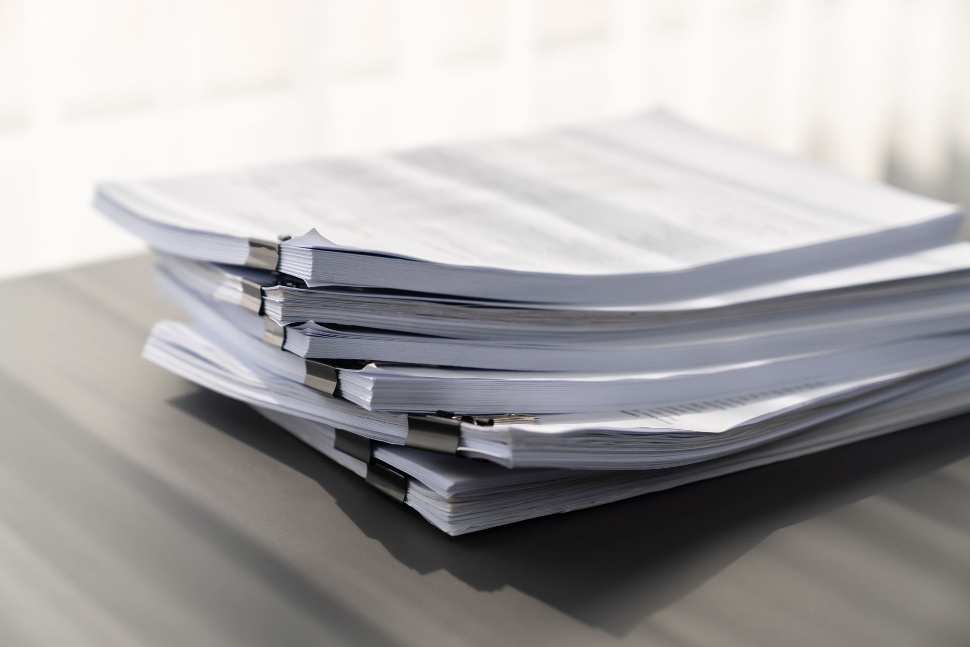 stack of papers A stack of papers sitting on top of each other on a table.