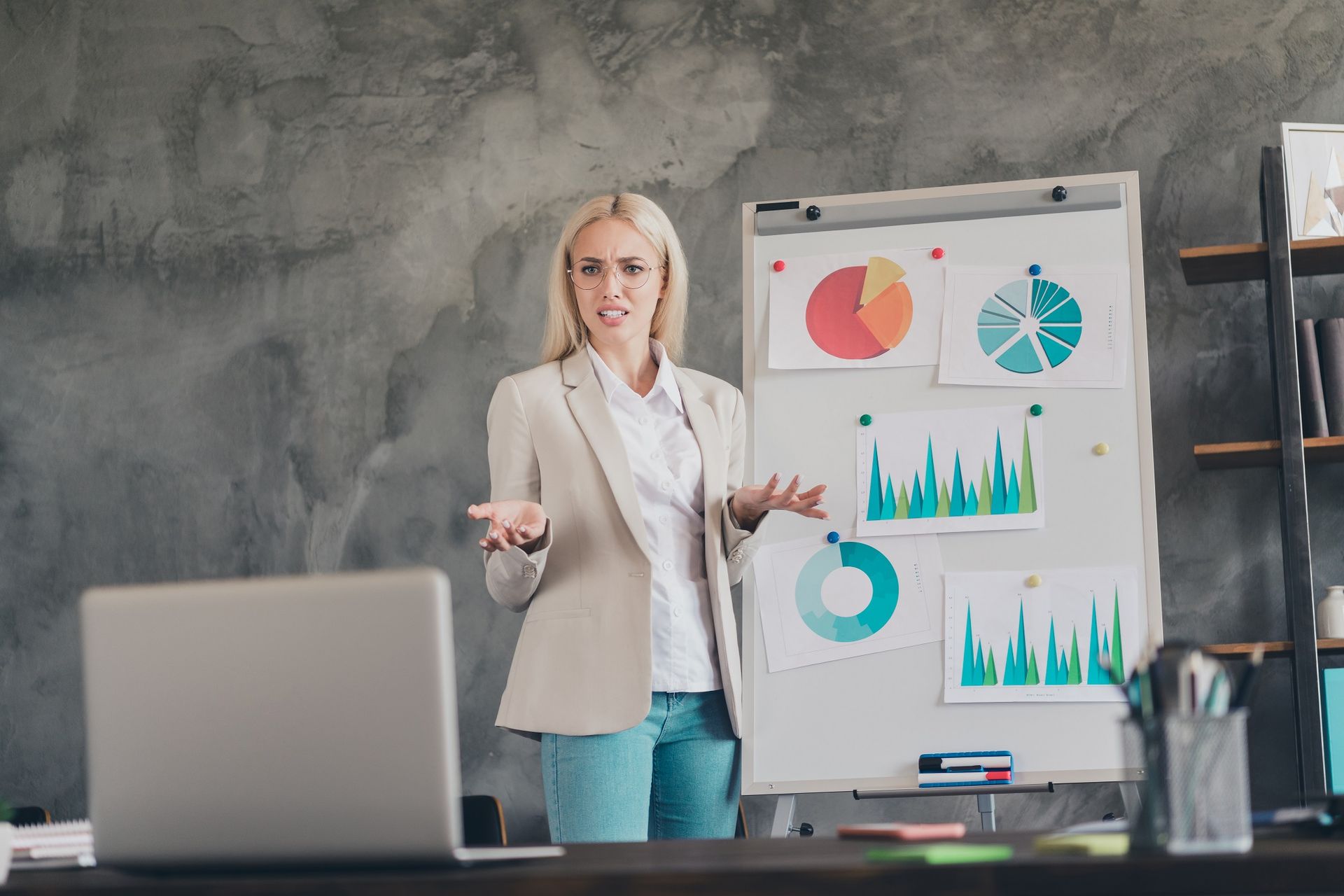 woman giving presentation in front of whiteboard A woman is giving a presentation in front of a whiteboard with graphs on it for Illustration of factors affecting premiums