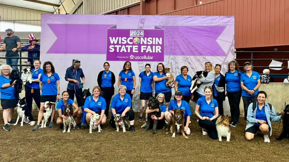 Group of people with dogs posing in front of a