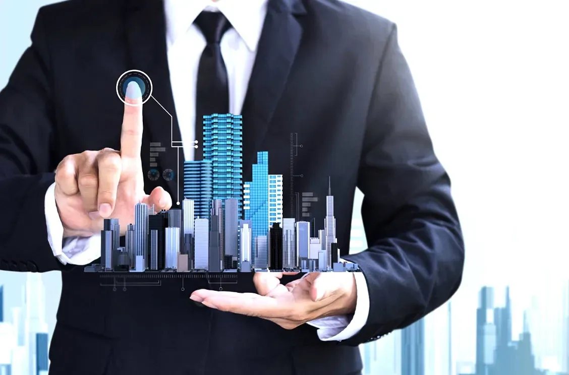 Businessman holding a futuristic city model with rising blue buildings and charts