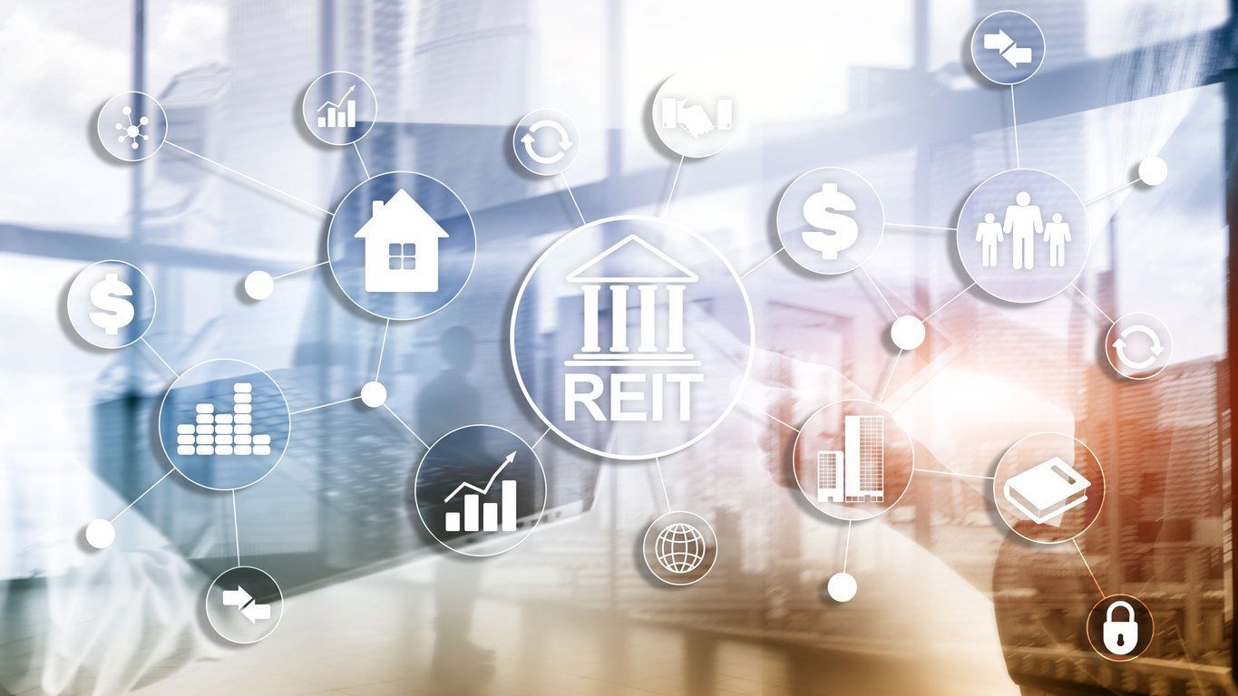 Glowing REIT icon with floating finance symbols, charts, home, and dollar signs in a blue office background