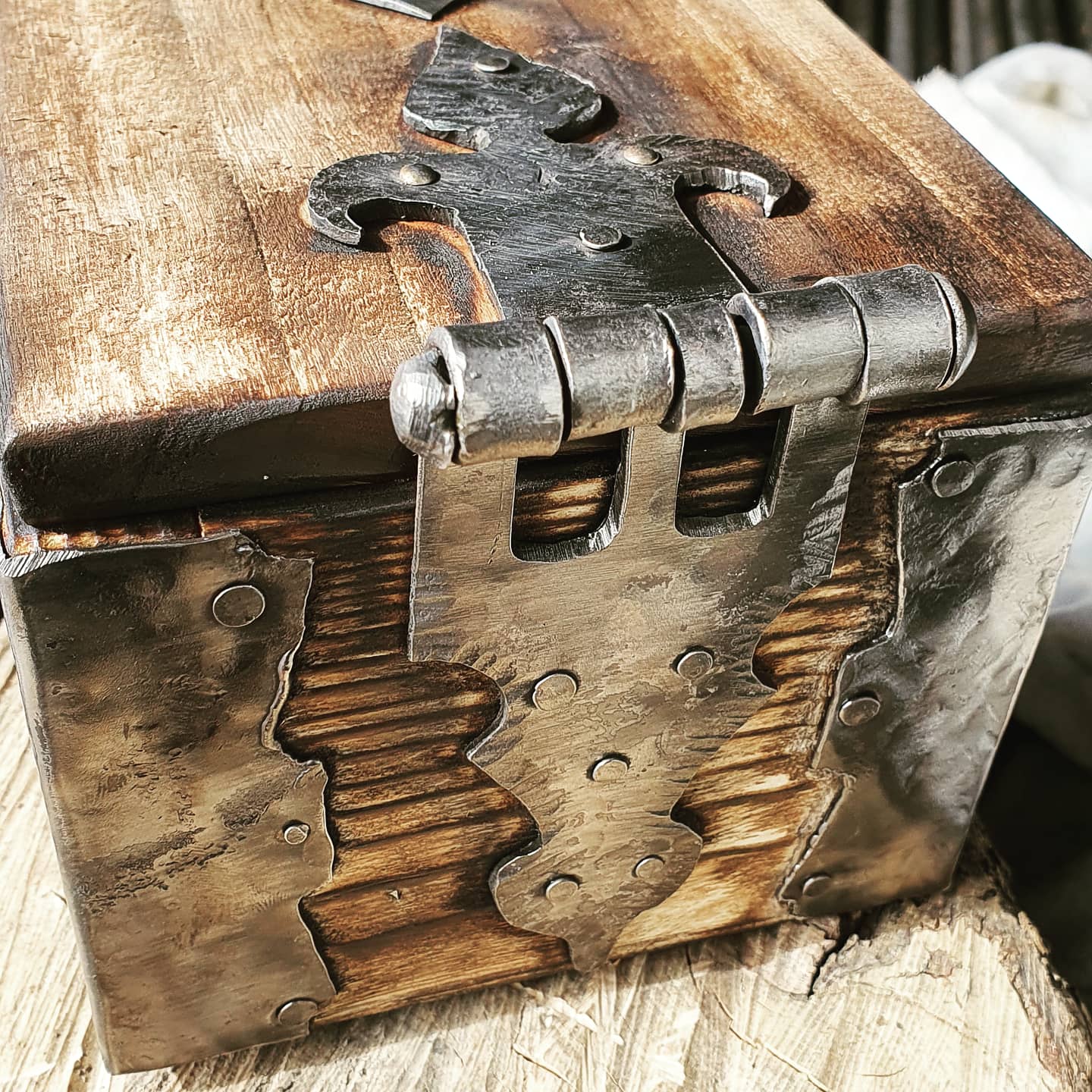 Scatola rustica in legno con cerniera in metallo e pannello frontale intagliato effetto invecchiato.